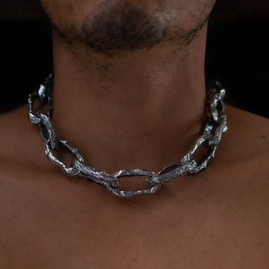 Close-up of a man wearing the Aji XL men's thick chain in sterling silver, featuring chunky, textured links around his neck.