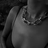 Aji XL sterling silver thick chain necklace worn on a woman's neck, captured in a grayscale photo.