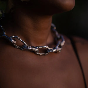 Close-up of Aji XL women's thick chain in sterling silver, worn on a woman's neck, showcasing chunky chain links.