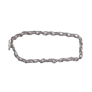 Ula sterling silver chunky chain with a shiny finish, featuring textured, interlocking links laid flat against a white background.