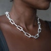 Close-up of a person wearing the Ula X silver thick chain necklace with rugged, large silver links, styled against dark skin.